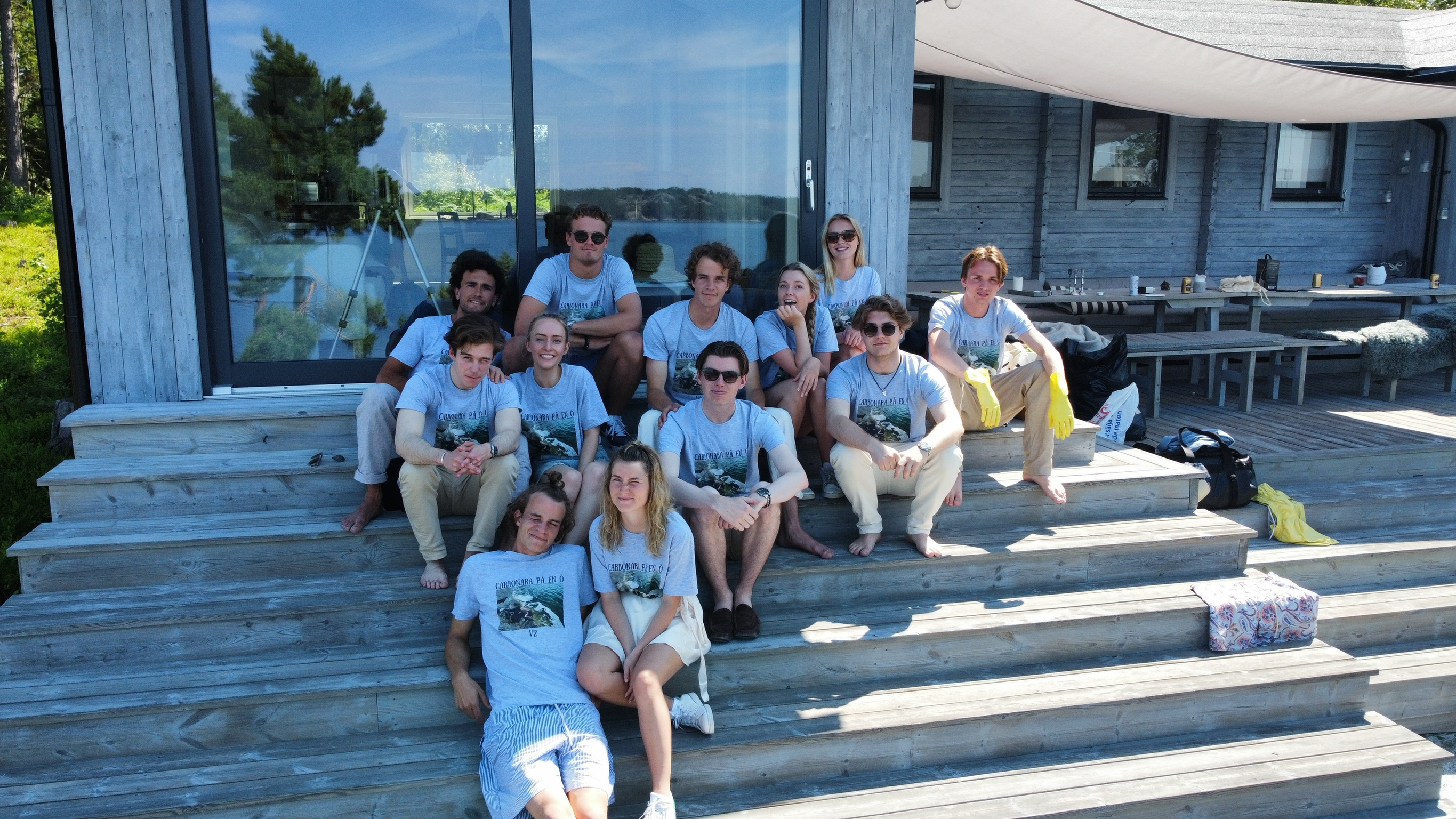 Friends in matching T-shirts on a wooden deck by the water